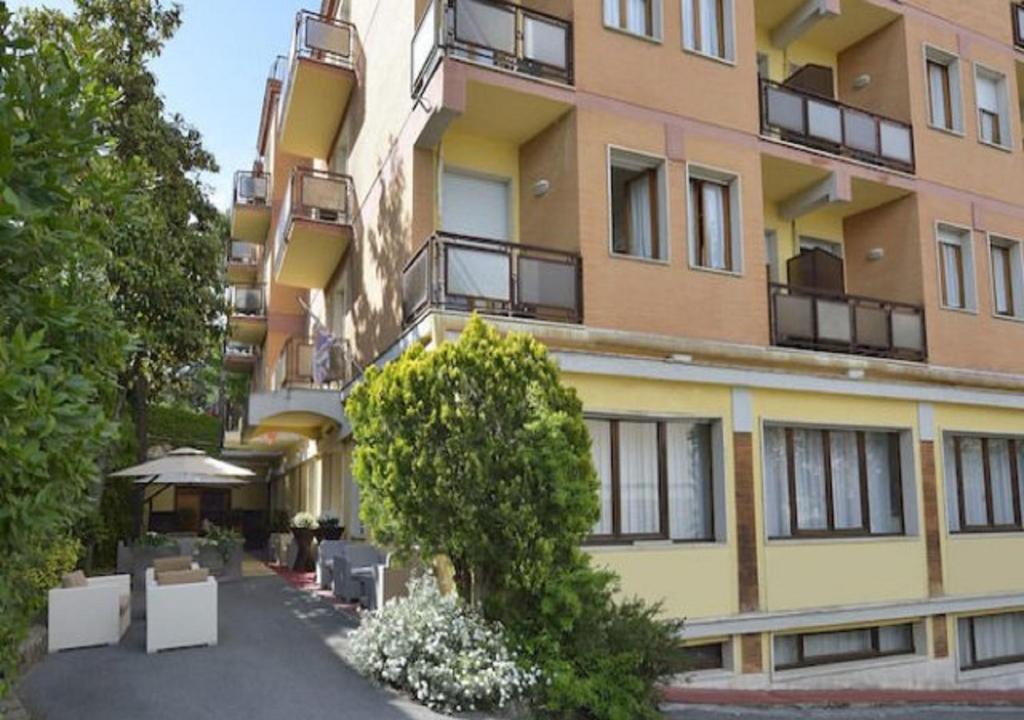 an apartment building with a courtyard in front of it at Nuovo Hotel Attico in Chianciano Terme
