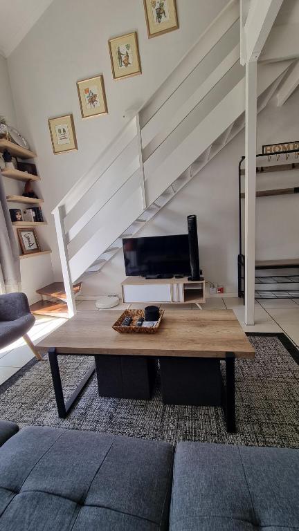 a living room with a table and a staircase at Urben Loft - Back up Power in Cape Town