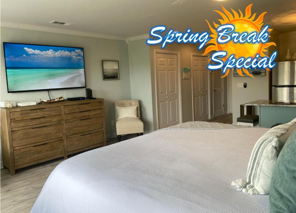 um quarto com uma cama e uma televisão na parede em Destin Bliss! Your Dream Studio Condo on Holiday Isle! em Destin