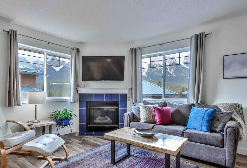 a living room with a couch and a fireplace at Big Mountain Views - 2-story Corner Unit in Canmore