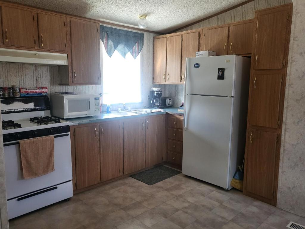 a kitchen with wooden cabinets and a white refrigerator at A rest after a day in the Death Valley desert in Scranton