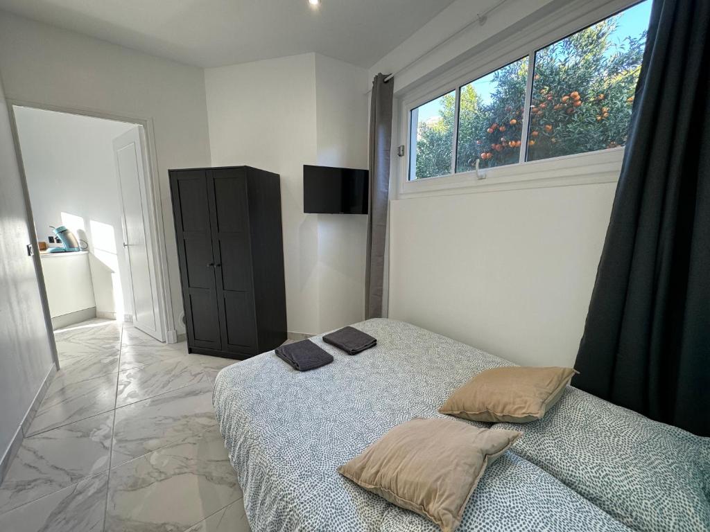 a bedroom with a bed with two pillows and a window at La maison de Giulia Menton in Menton