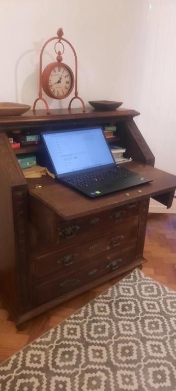 a laptop computer sitting on a desk with a clock at Casa Mateus - Colares, Parque Natural Sintra Cascais in Sintra
