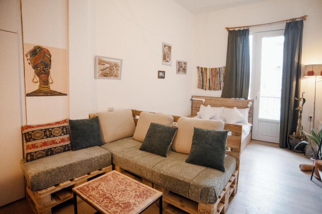 ein Wohnzimmer mit einem Sofa und einem Tisch in der Unterkunft Stylish cozy studio guesthouse in the city center in Tbilisi City