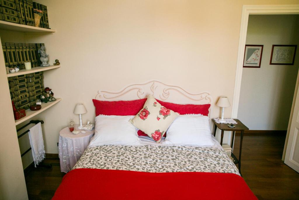a bedroom with a red and white bed with pillows at B&B Agapantus in una Villa dell'800 in Dolceacqua