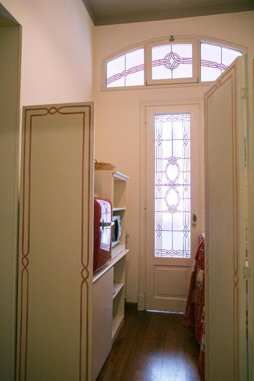 a room with a door and a window and a tv at B&B Agapantus in una Villa dell'800 in Dolceacqua
