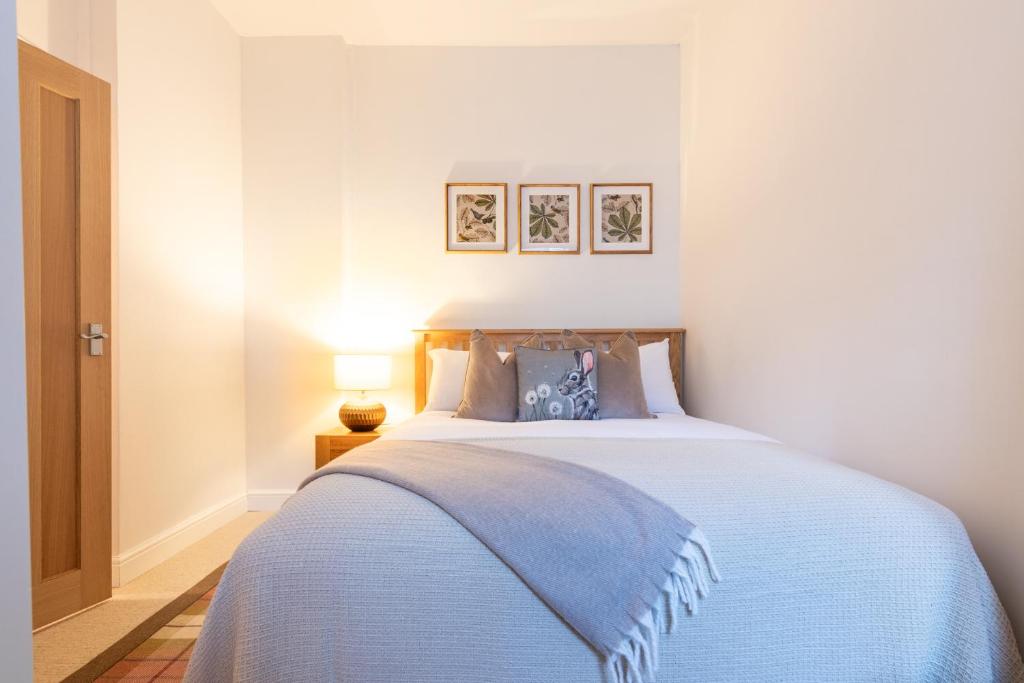 a bedroom with a bed with a blue blanket at The Tartan Terrace in Inverness