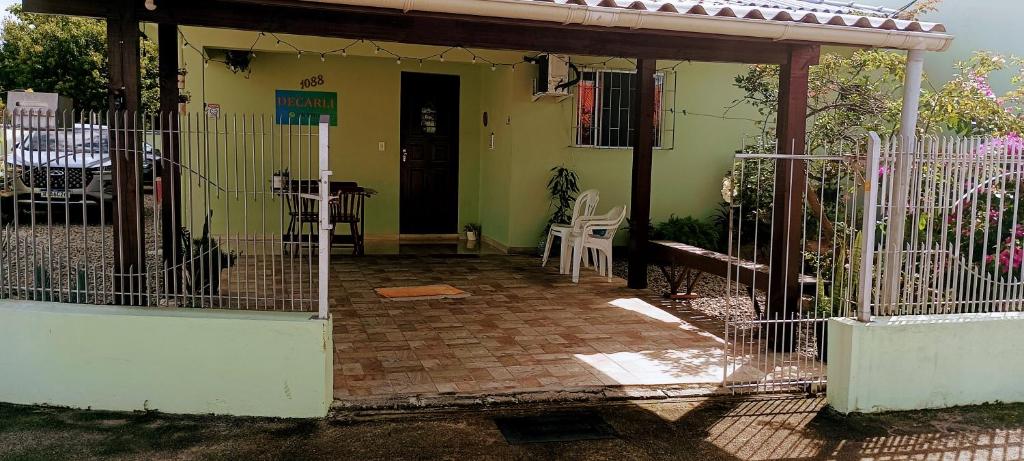a gate to a house with a table and chairs at Pousada Decarli Executiva Aeroporto Florianópolis in Florianópolis