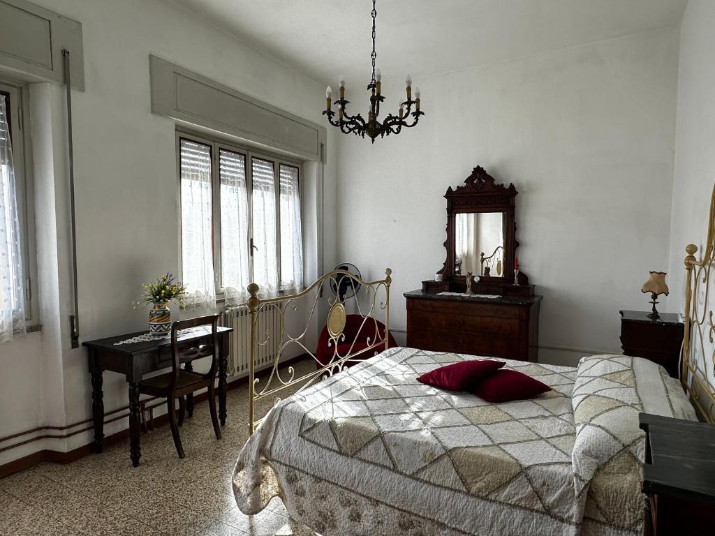 um quarto com uma cama, uma secretária e um lustre em Casa Valentina em Capannori