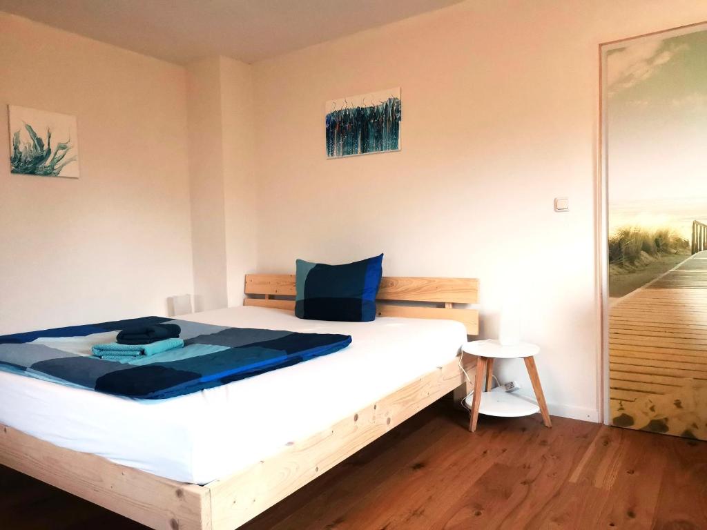 een slaapkamer met een wit bed en een blauw kussen bij InnBlick Ferienwohnungen in Gars am Inn
