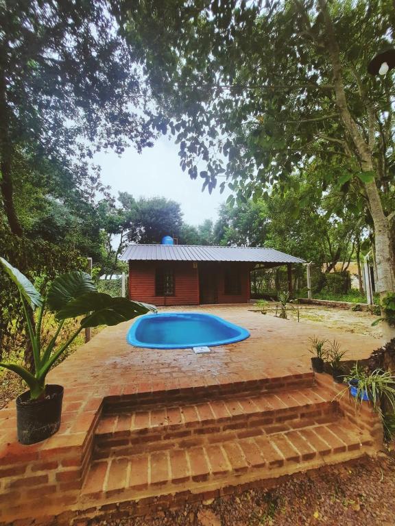 a swimming pool in a yard with a house at Cabañas Carayá in Paso de la Patria