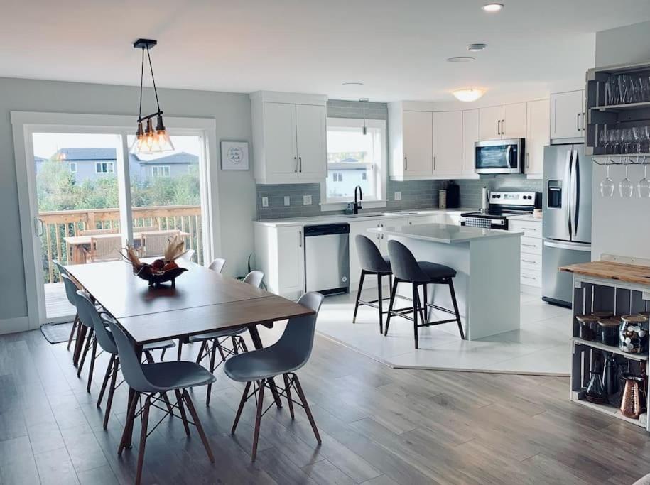 a kitchen and dining room with a table and chairs at Luxury Home with Gym, Sauna, Patio, and AC in Halifax