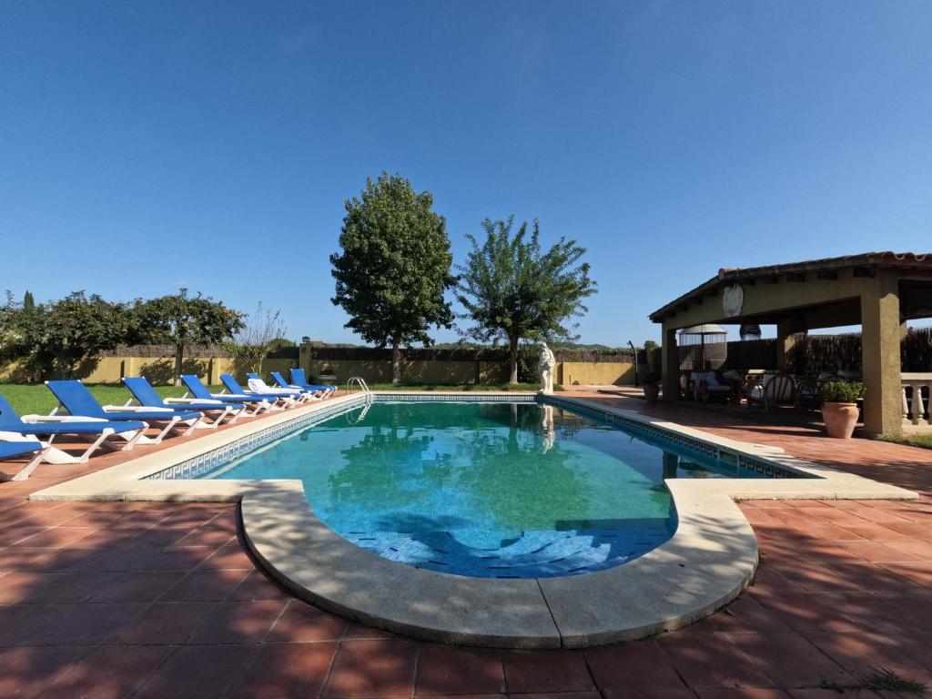 a swimming pool with lounge chairs and a pavilion at Amazing villa for big groups in the best place of Costa Brava in Palamós