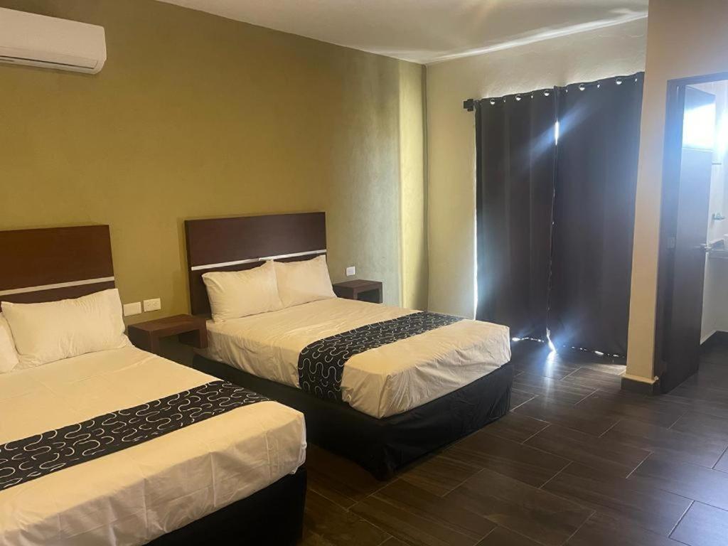 a hotel room with two beds and a window at REGMAR Progreso Yucatán in Progreso