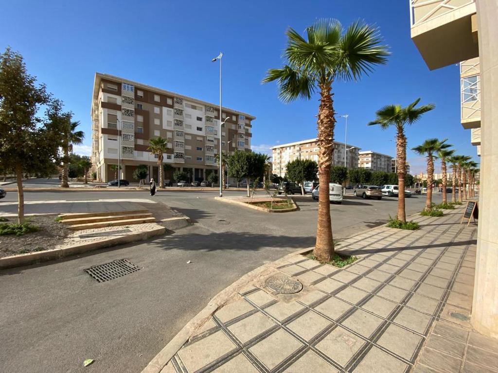 una calle vacía con una palmera y un edificio en appart luxe CORALIA 34 IL 7 en Oujda