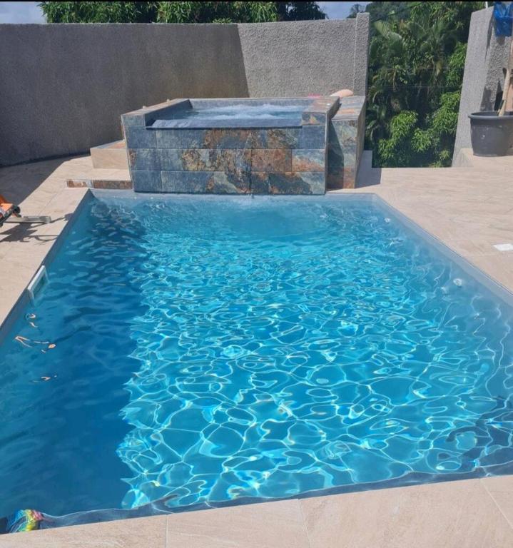a swimming pool with a fountain in the middle at Paradis Spiritain in Saint Esprit