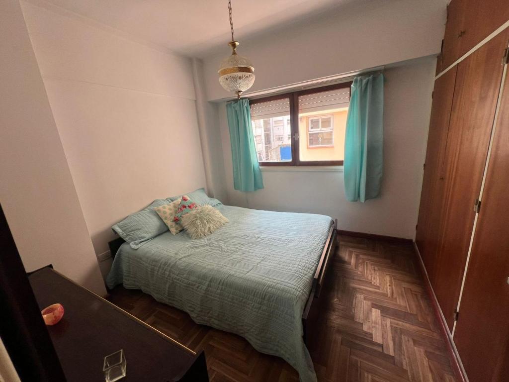 um pequeno quarto com uma cama e uma janela em Departamento en Mar del Plata em Mar del Plata