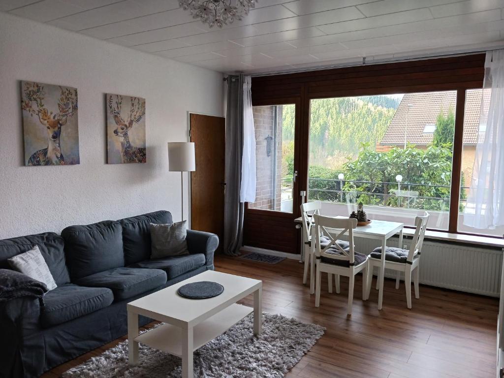 a living room with a couch and a table at HARZ-LIEBE Lautenthal in Langelsheim