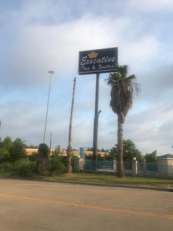 a sign for a restaurant with a palm tree at executive inn & suites in Lufkin