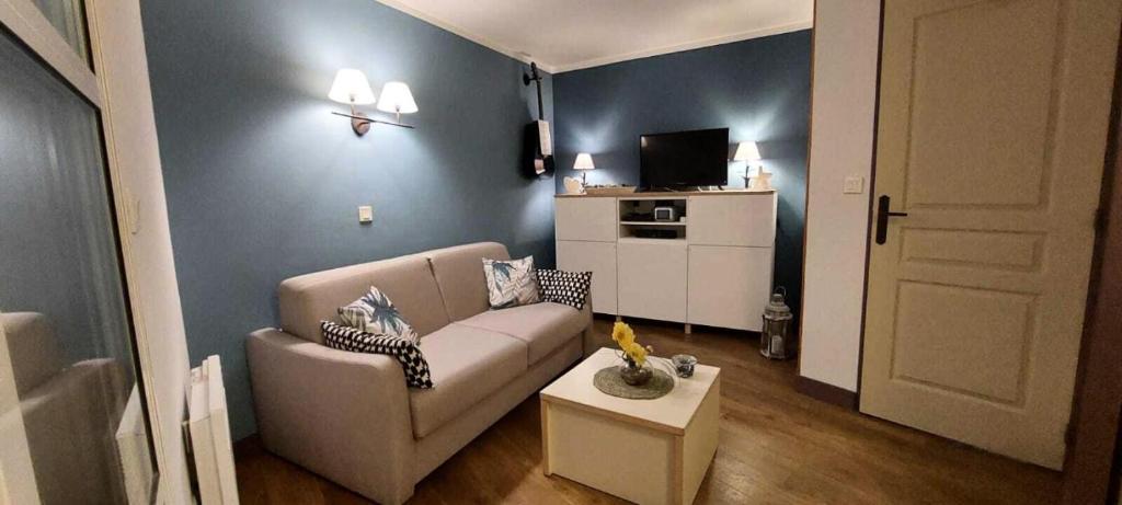 sala de estar con sofá y mesa en Résidence le Village de Cap Esterel - maeva Home - Appartement 2 pièces 5 p 27, en Saint-Raphaël