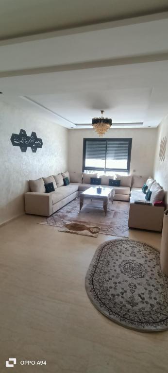 un soggiorno con 2 divani e un tavolo di Victoria Mohammed V-Apartment a Bouskoura