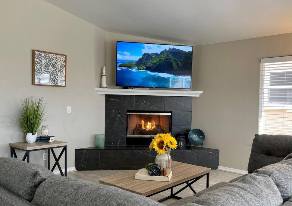 a living room with a fireplace and a tv at Multi Family! 2 min walk to Beach! EV Charger! in Oceano