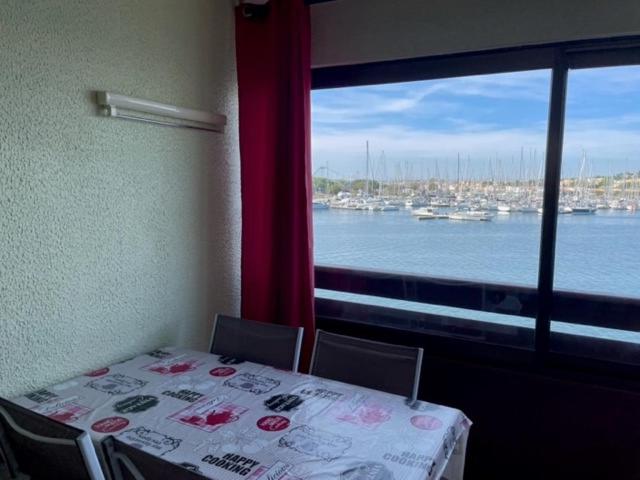 - une table dans une chambre avec vue sur l'eau dans l'établissement studio cabine avec loggia Cap d Agde, au Cap d'Agde