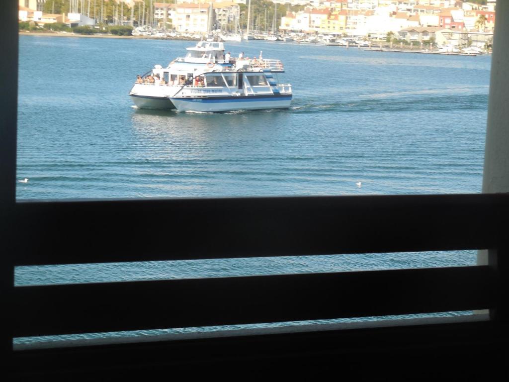 a large boat on the water in a river at studio cabine avec loggia Cap d Agde in Cap d'Agde