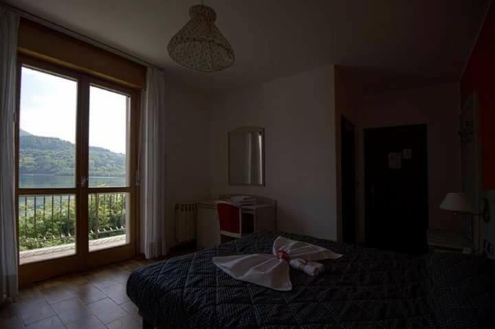 - une chambre avec un lit et une grande fenêtre dans l'établissement Albergo Mezzolago, à Pergine Valsugana