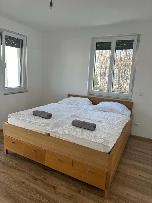 a bedroom with a large bed with two pillows on it at Neubauwohnung gleich bei der Bushaltestelle - Apartment 2a in Vienna