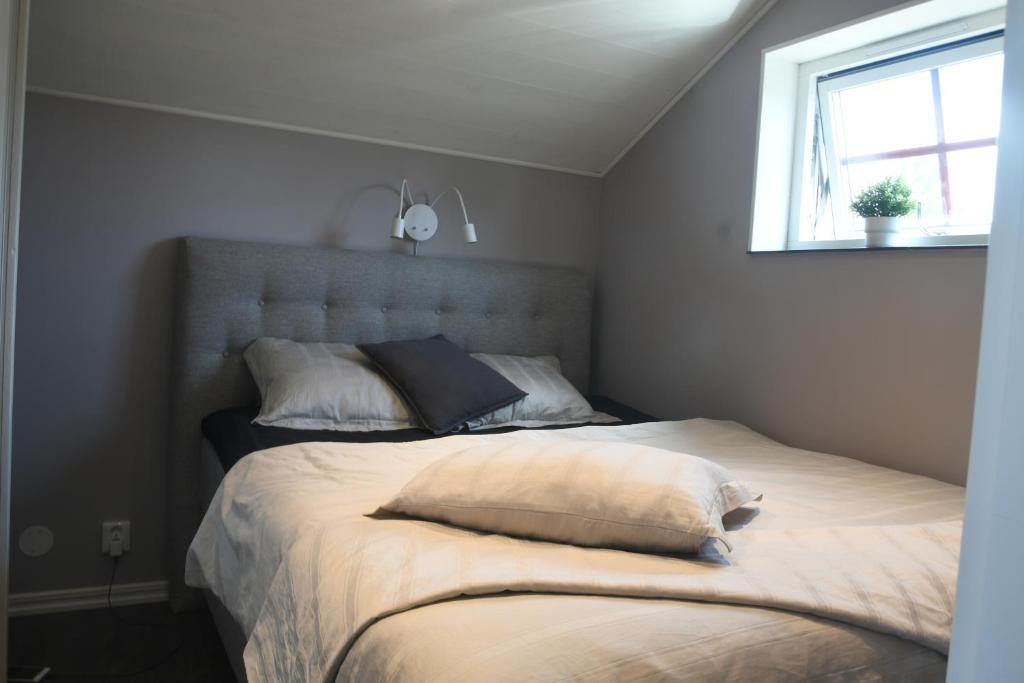 a bedroom with a bed with two pillows and a window at Apartment Berghem Grönadal Nättraby in Nättrabyhamn
