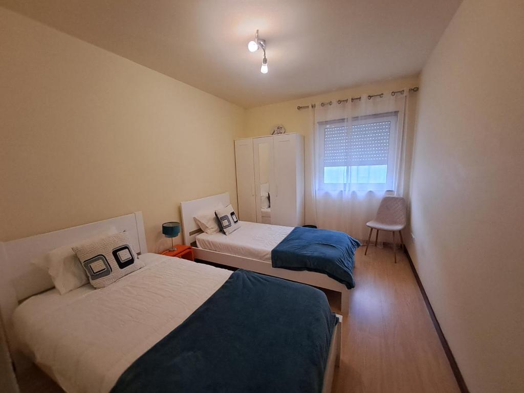 a bedroom with two beds and a window at Apartment Sweet Home in Ponta Delgada