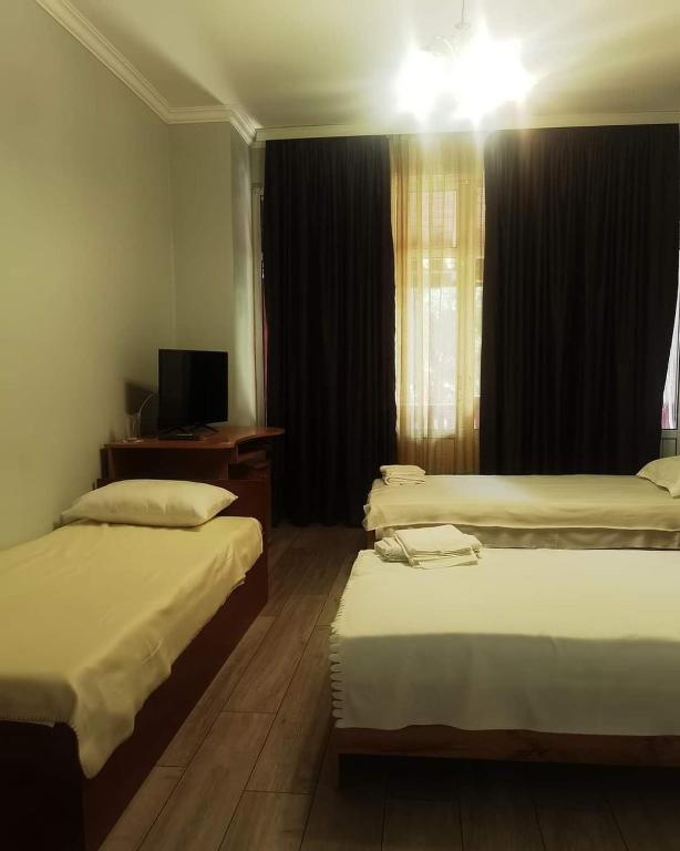 a hotel room with two beds and a television at CITY HOUSE in Dulovo