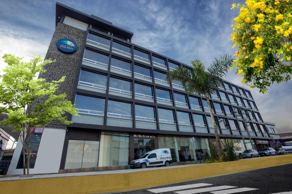 un edificio con una furgoneta blanca estacionada frente a él en Hotel Poza Rica Centro, en Poza Rica de Hidalgo