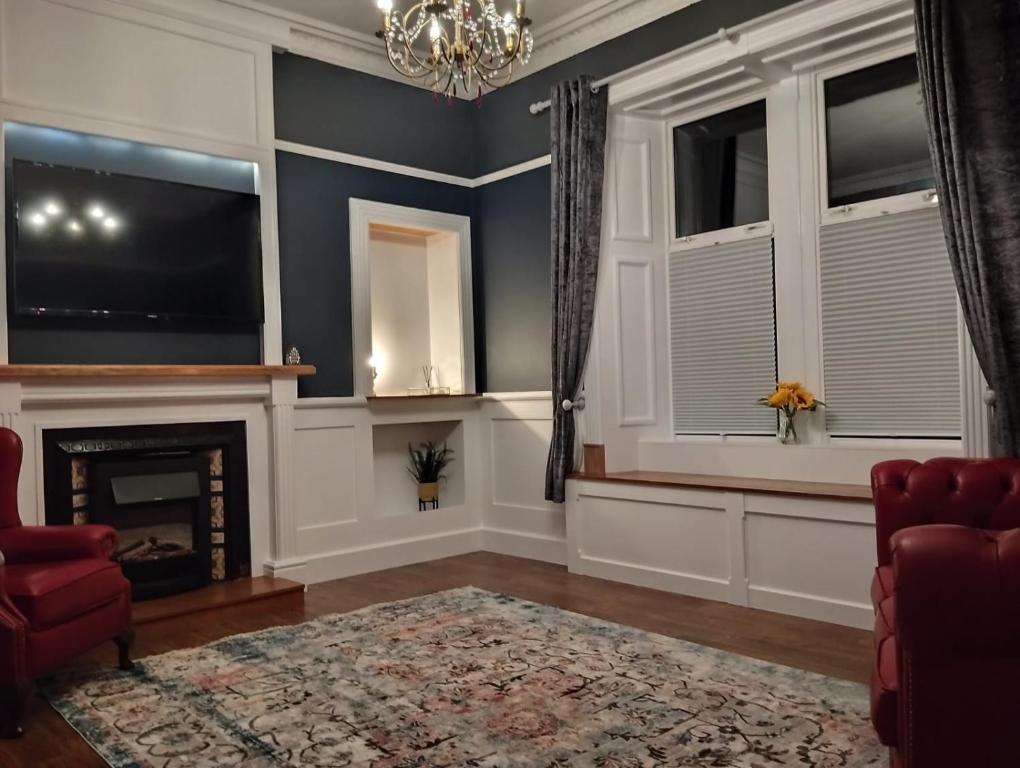 a living room with a fireplace and a chandelier at Lorne View in Oban