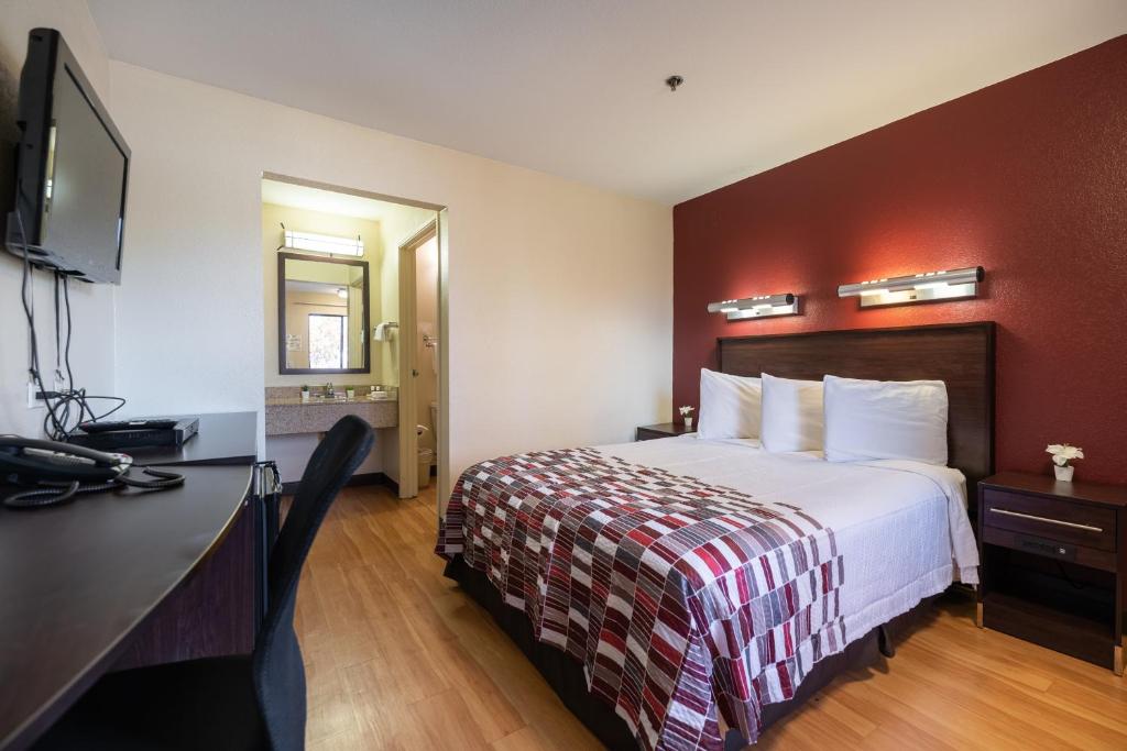 Habitación de hotel con cama y TV de pantalla plana. en Sacramento Inn & Suites en Sacramento