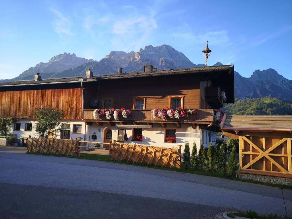 a house with flowers on the side of it with mountains at Stockingbauer in Leogang