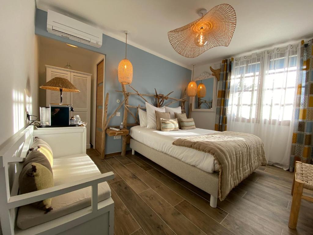 Un dormitorio con una cama y una mesa. en Hôtel Le Neptune en Camargue, en Saintes-Maries-de-la-Mer