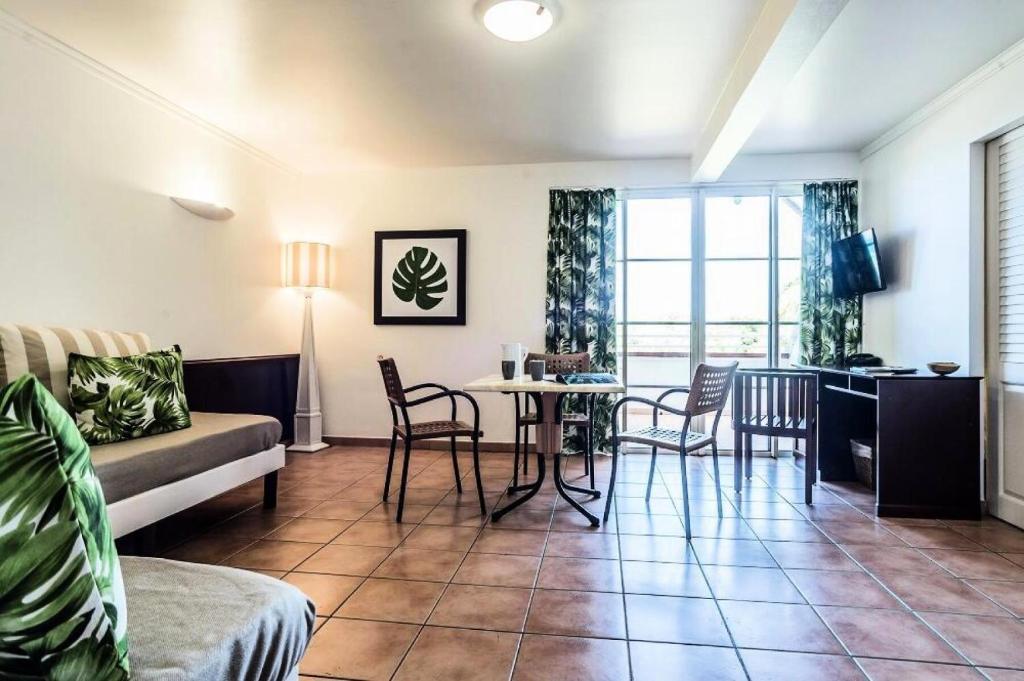 een woonkamer met een bank en een tafel en stoelen bij Village Sainte Luce, Martinique - maeva Home - Appartement 3 pièces 6 perso 861 in Sainte-Luce