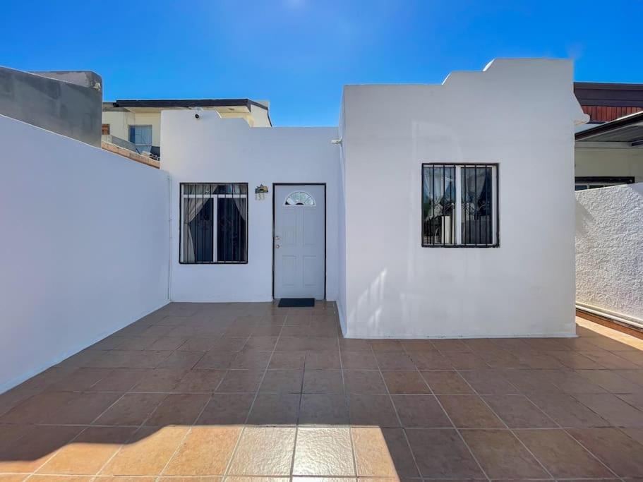 a white building with a door and a tile floor at Comfortable family friendly Home 133 in Puerto Peñasco