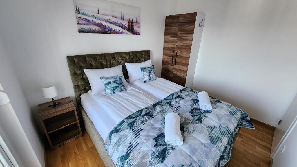- une chambre avec un lit doté de draps blancs et d'oreillers bleus dans l'établissement Ada Nostra, à Banja Luka