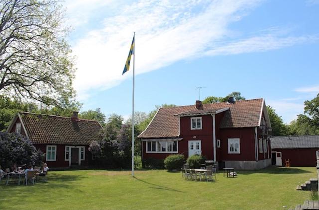 una casa con una bandera delante de un patio en Sandby Pensionat en Löttorp
