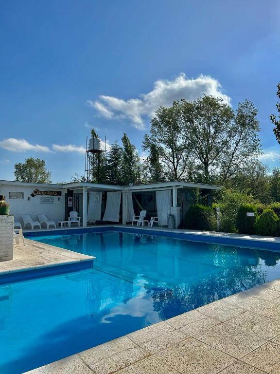 a swimming pool with blue water in front of a house at BARRIO VIEJO in Los Reartes