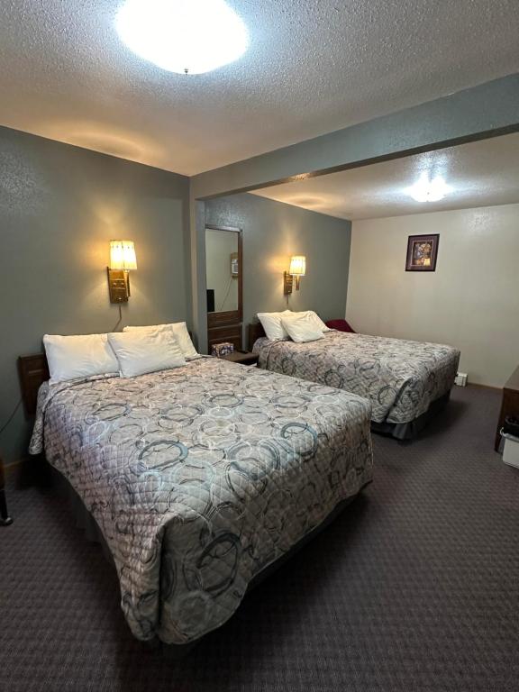 a hotel room with two beds and a mirror at Sportsman Motel in Malta