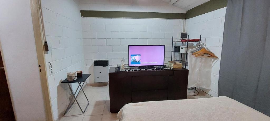 a room with a computer on a desk with a bed at La Casita de Marley in Villa Santa Cruz del Lago