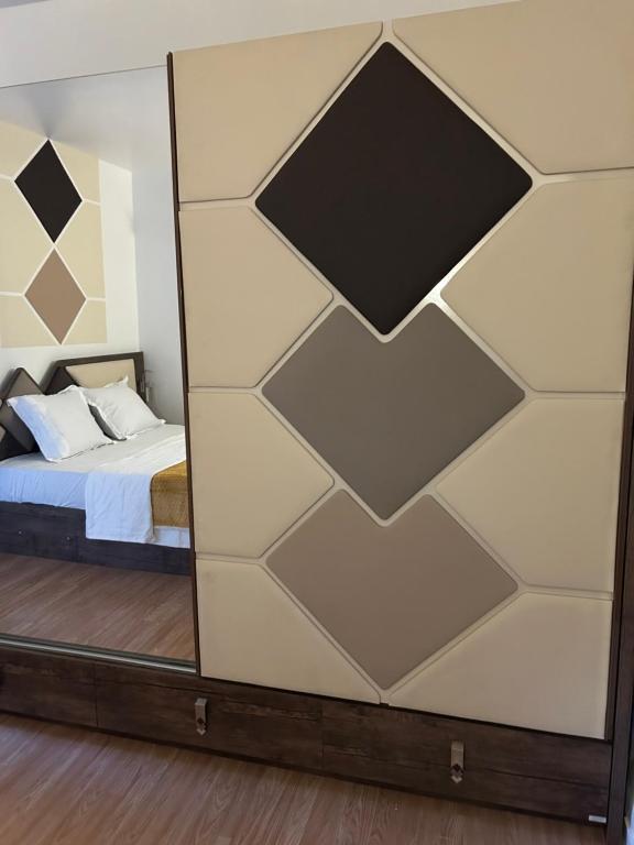 Cette chambre comprend un lit et un miroir mural. dans l'établissement Chez Chantou à Pierrefitte sur Seine, à Pierrefitte-sur-Seine