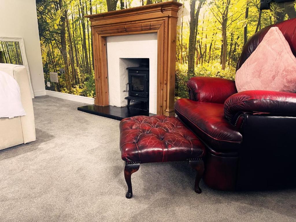 a living room with a leather chair and a fireplace at Willow’s Abode: Luxury One Bed in Newton in Makerfield