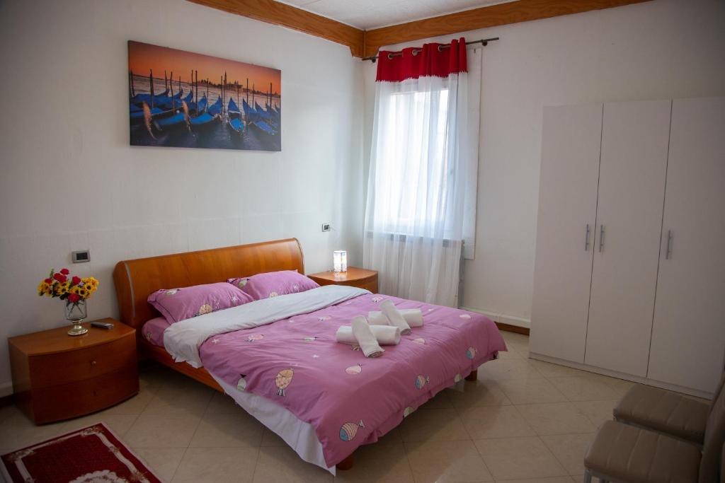 1 dormitorio con 1 cama con edredón rosa en BB CA VENEZIA en Marghera