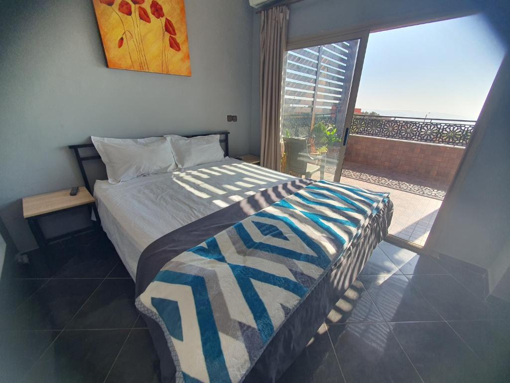 a bedroom with a bed and a large window at la sublime in Taghazout