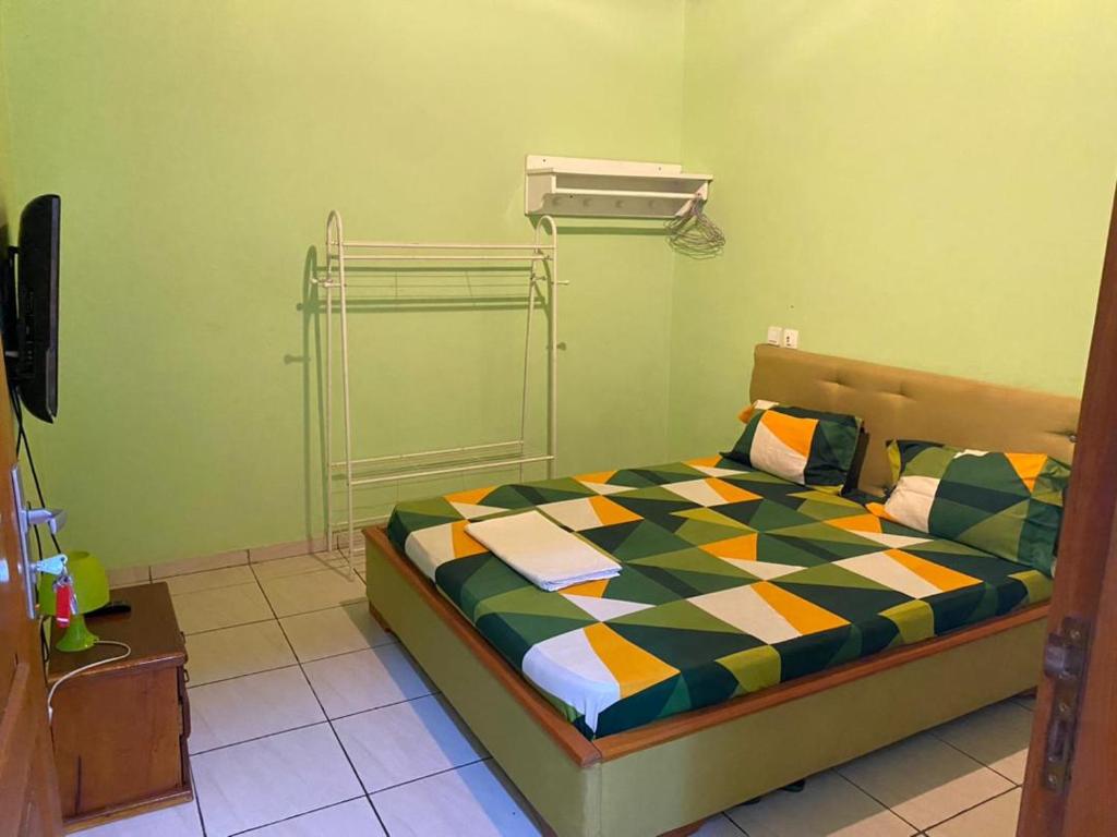 ein Schlafzimmer mit einem Bett in einem Zimmer in der Unterkunft Cave Royale - Chambres-Studios-Apparts meublés - Logpom Hopithal des soeurs ápres Camara Laye in Douala